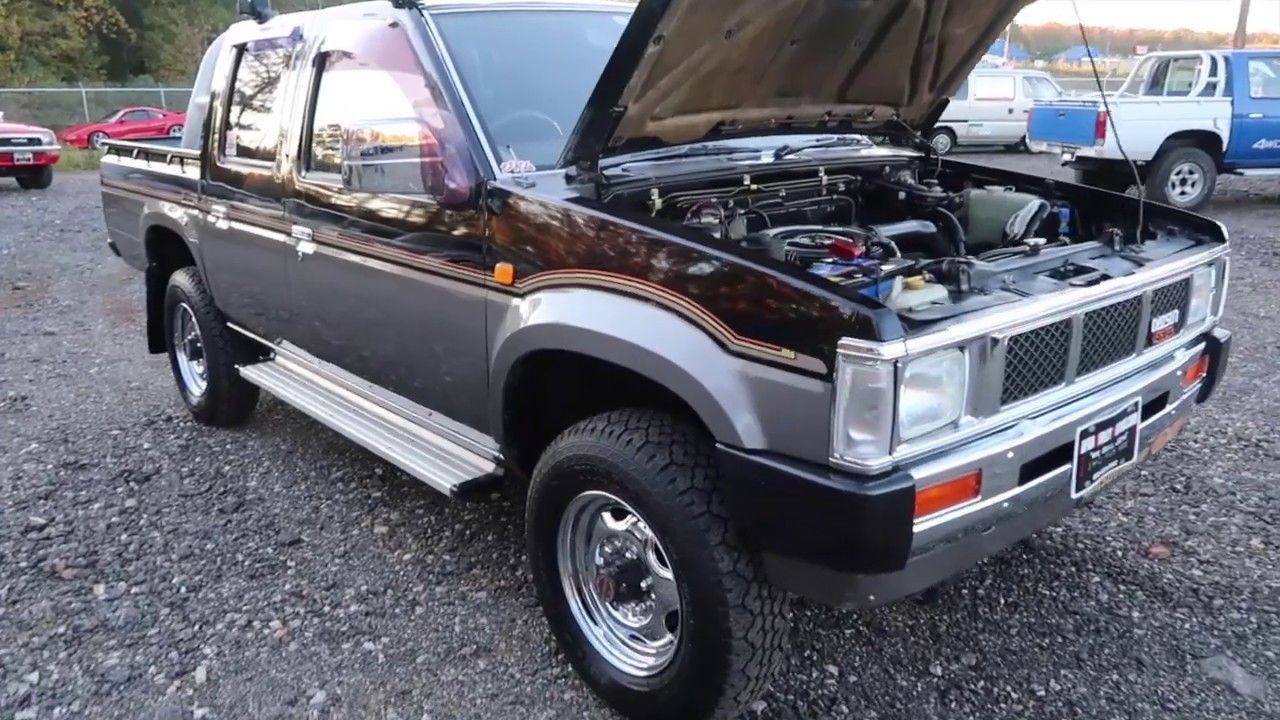 A parked 1990 Nissan D21 Diesel with the hood up