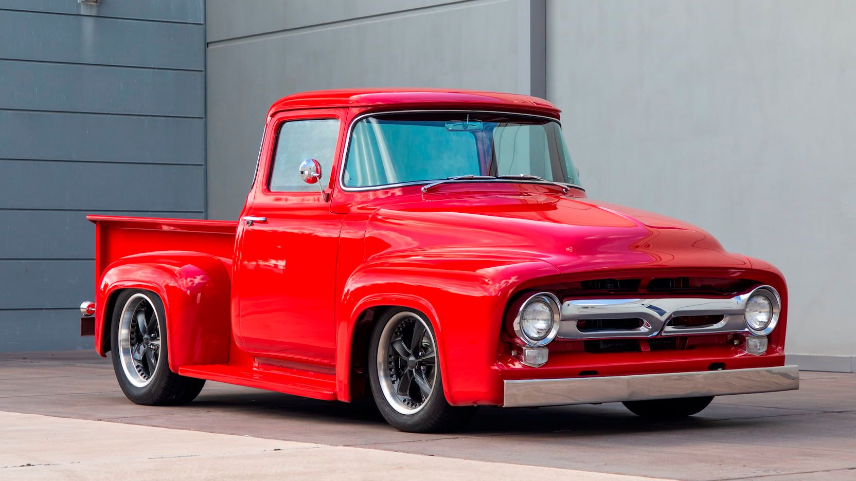 A parked red 1956 Ford F100