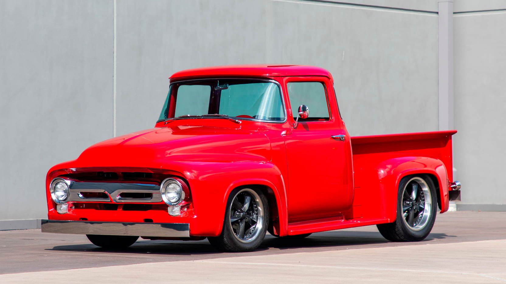 A parked red 1956 Ford F100