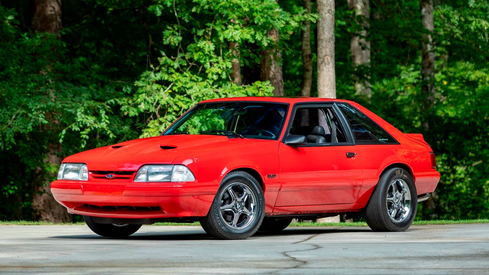 A parked red 1993 Ford Mustang LX