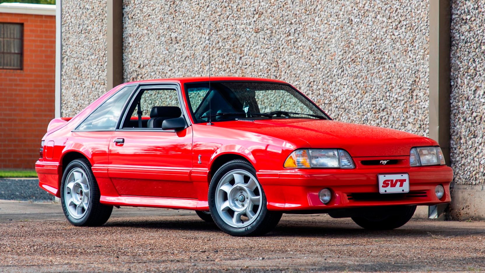 A parked red 1993 Ford Mustang SVT Cobra
