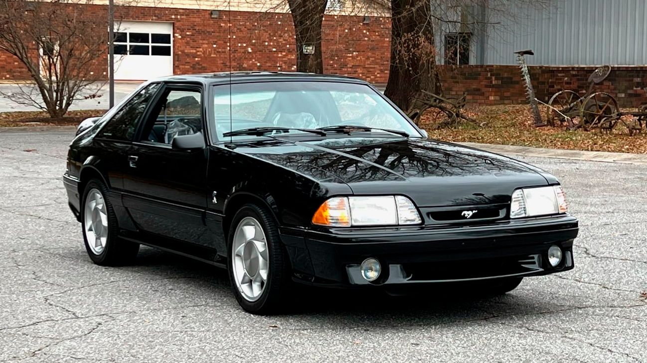 A parked black 1993 Ford SVT Cobra Mustang