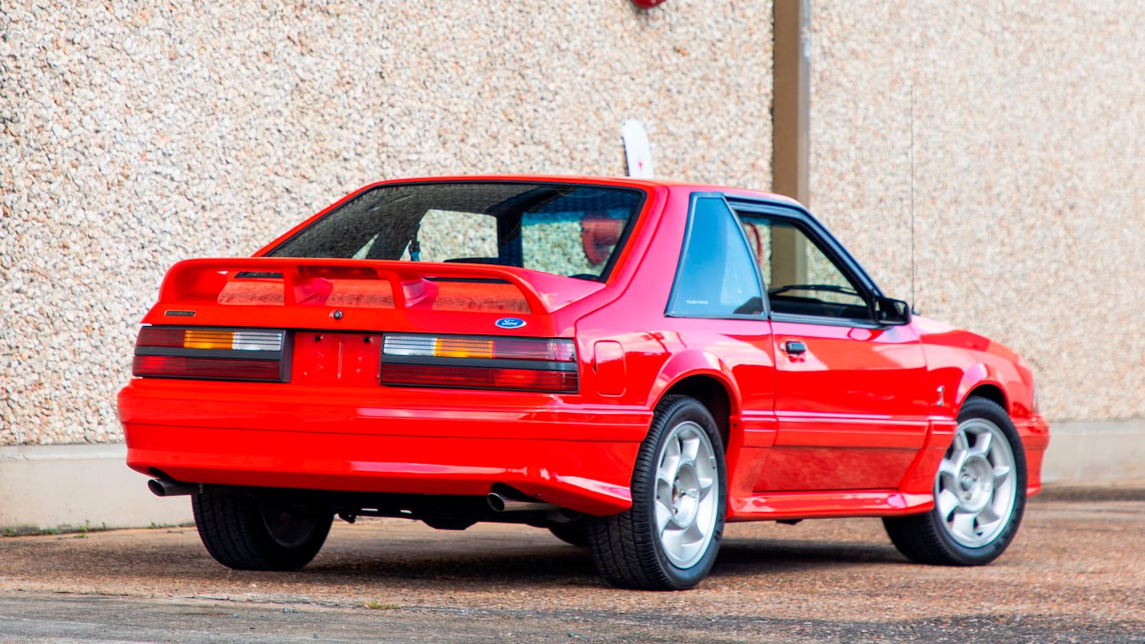 A parked red 1993 Ford SVT Cobra Mustang