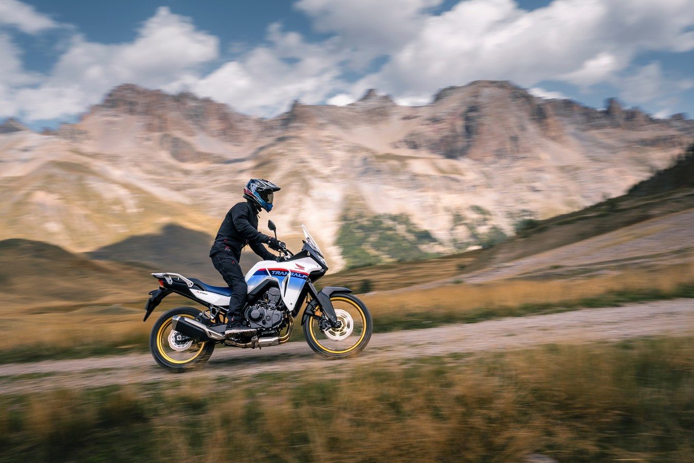 Action shot of a 2023 Honda Transalp XL750 driving along a mountain range