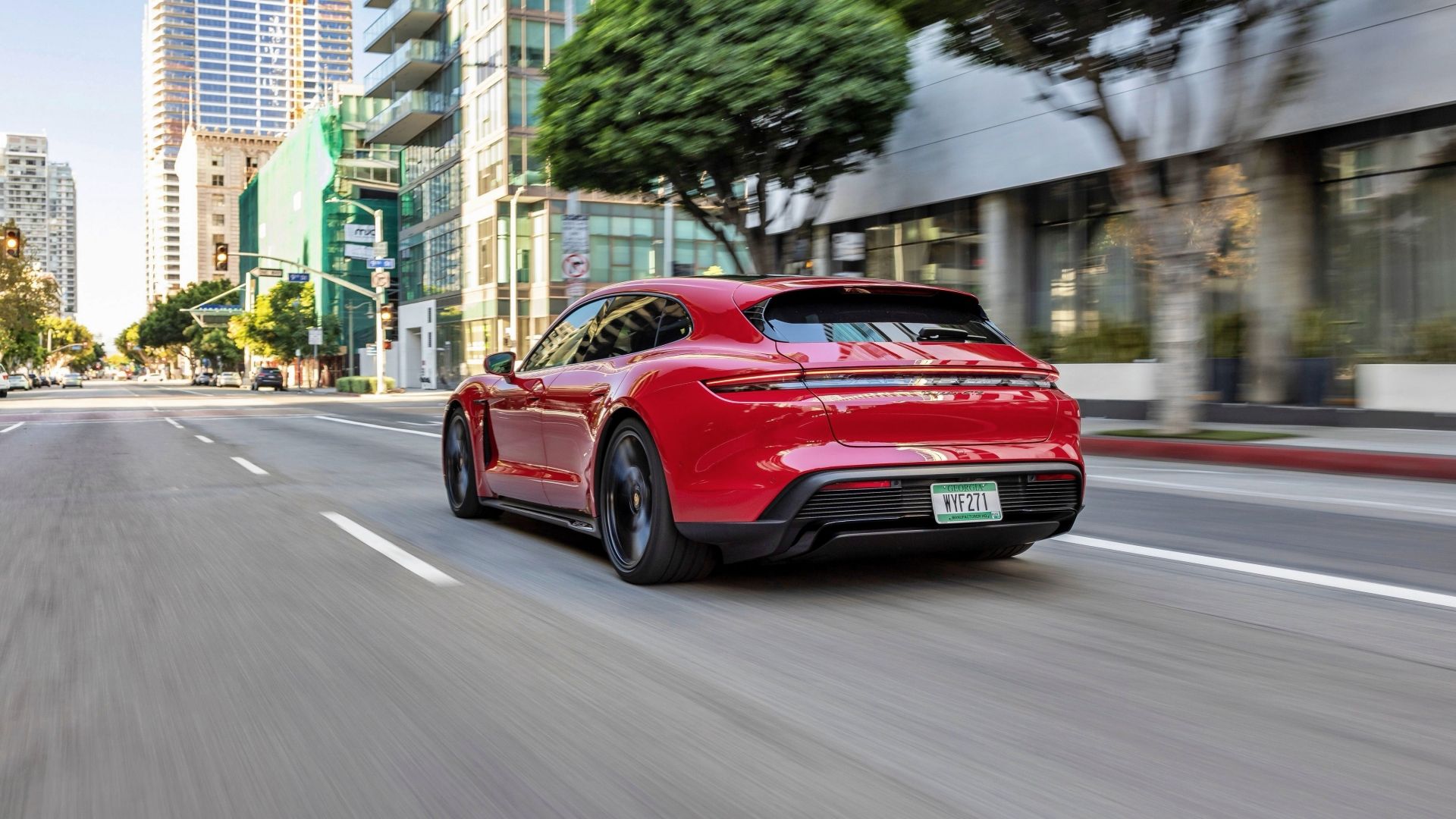 A red Porsche Taycan GTS Sport Turismo driving