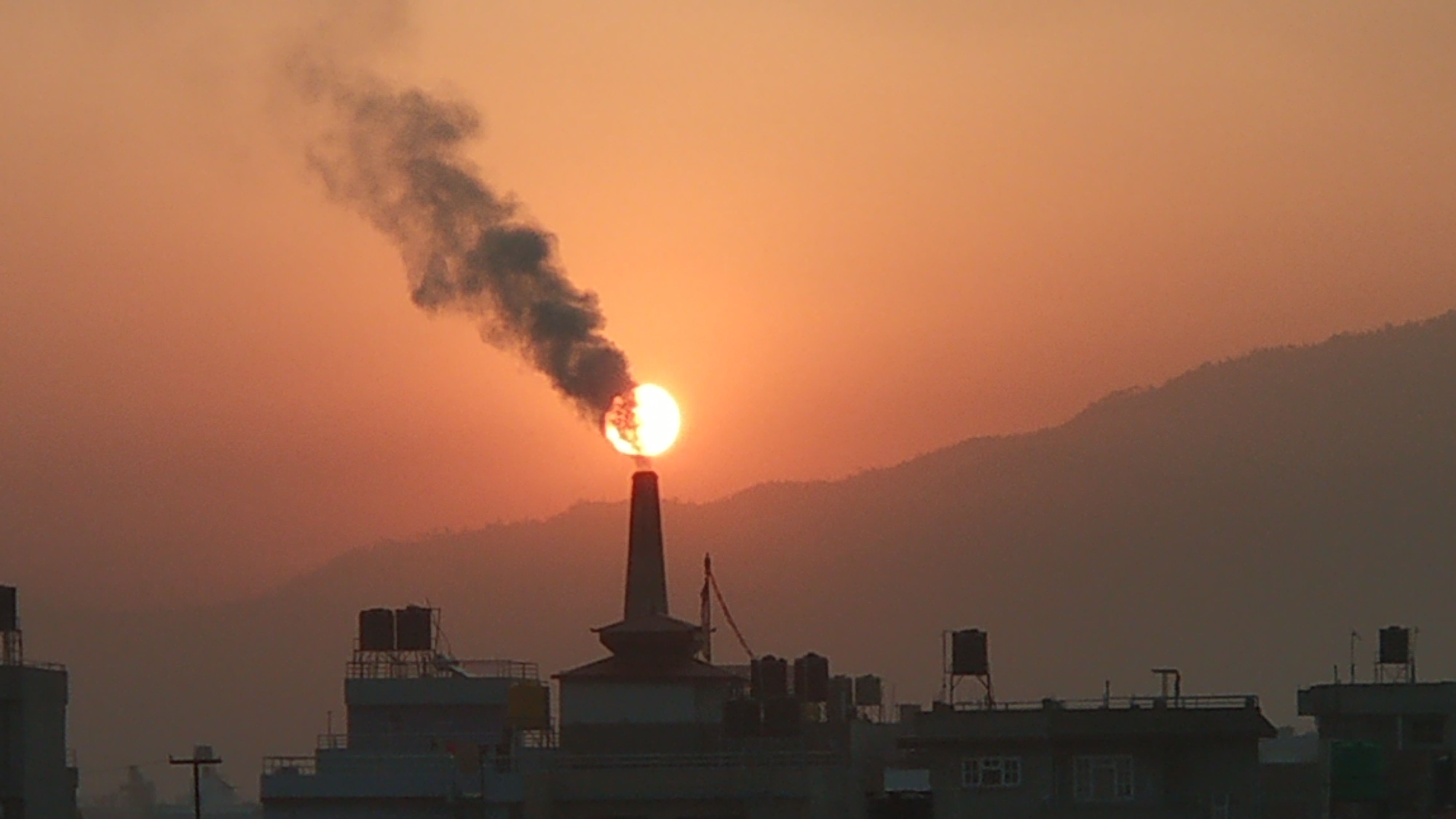 Factory spews air pollution into the sunset