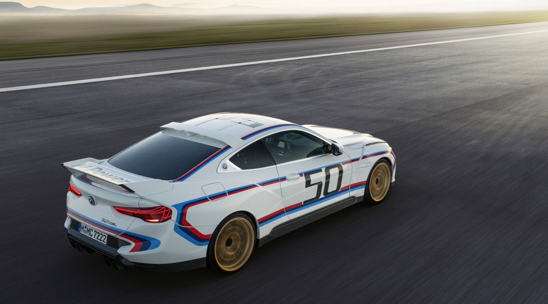 Dynamic shot of a 2023 BMW 3.0 CSL driving on a road. 