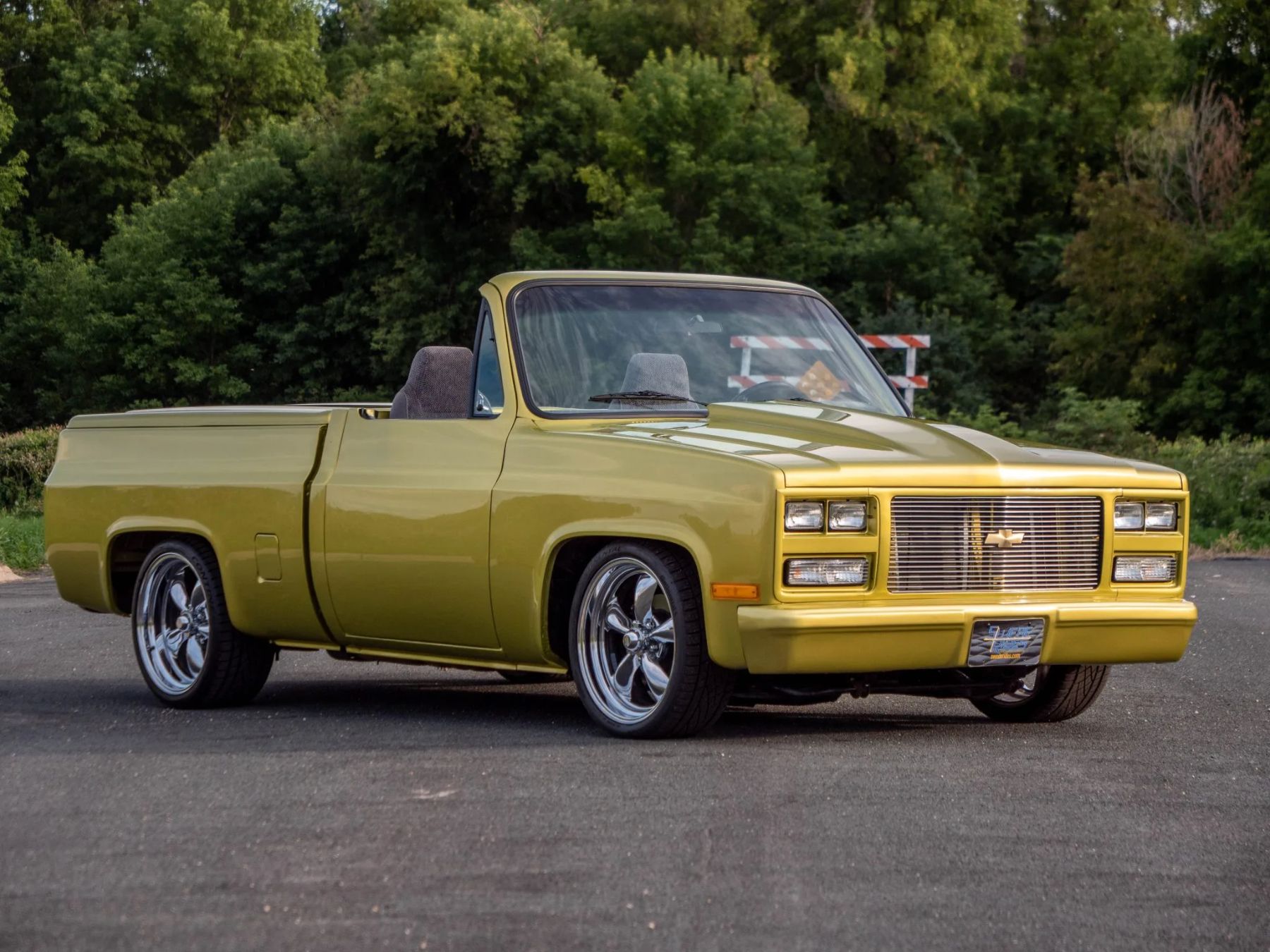 A front three-quarters shot of a gold modified 1979 Chevrolet C10 square body.