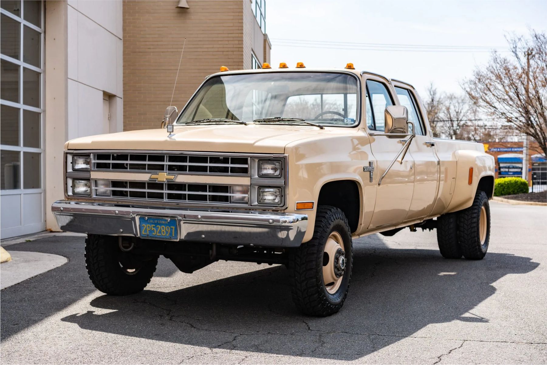 A front three-quarters shot of a beige 1985 Chevrolet K30 Crew Cab dually diesel. 