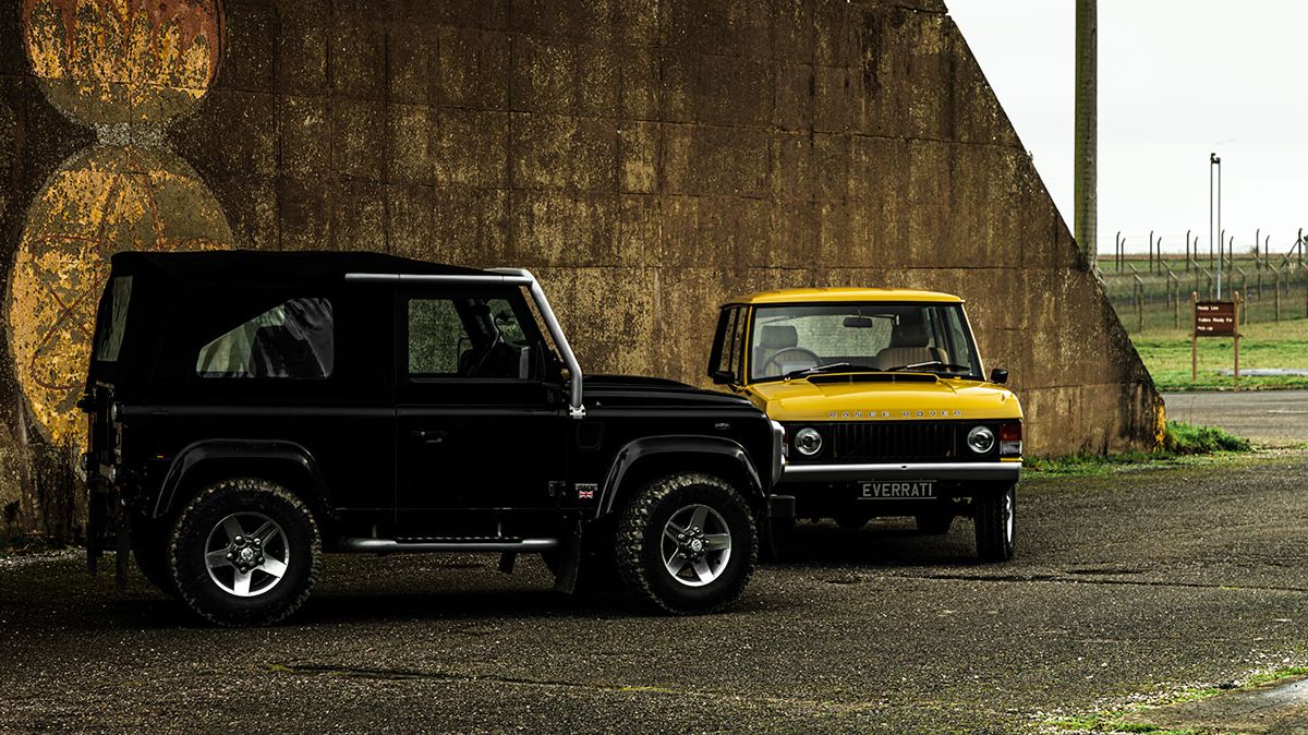 Black Land Rover Defender and yellow Range Rover Classic parked