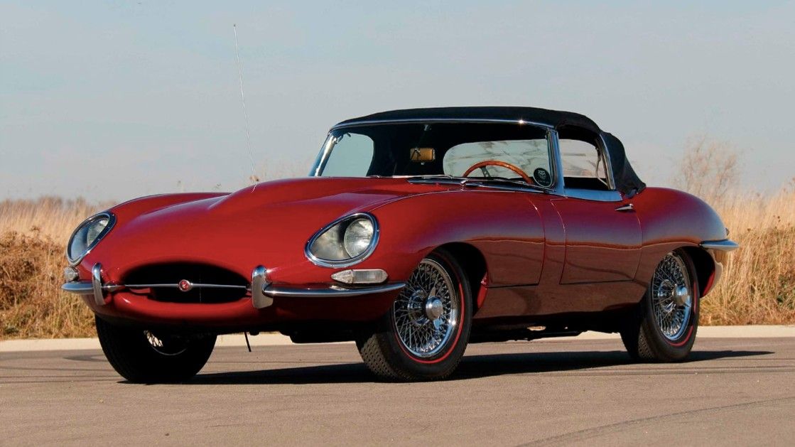 Driver's side shot of a red E-Type Roadster. 
