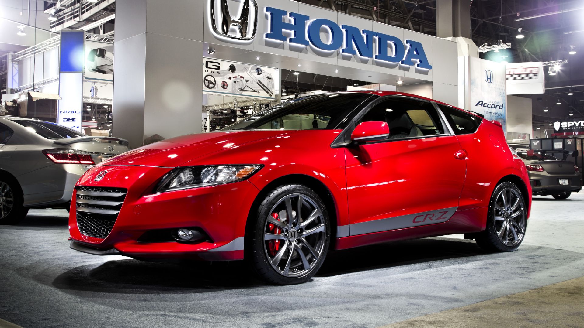 Static front three-quarters shot of a red 2015 HPD Honda CR-Z on display.