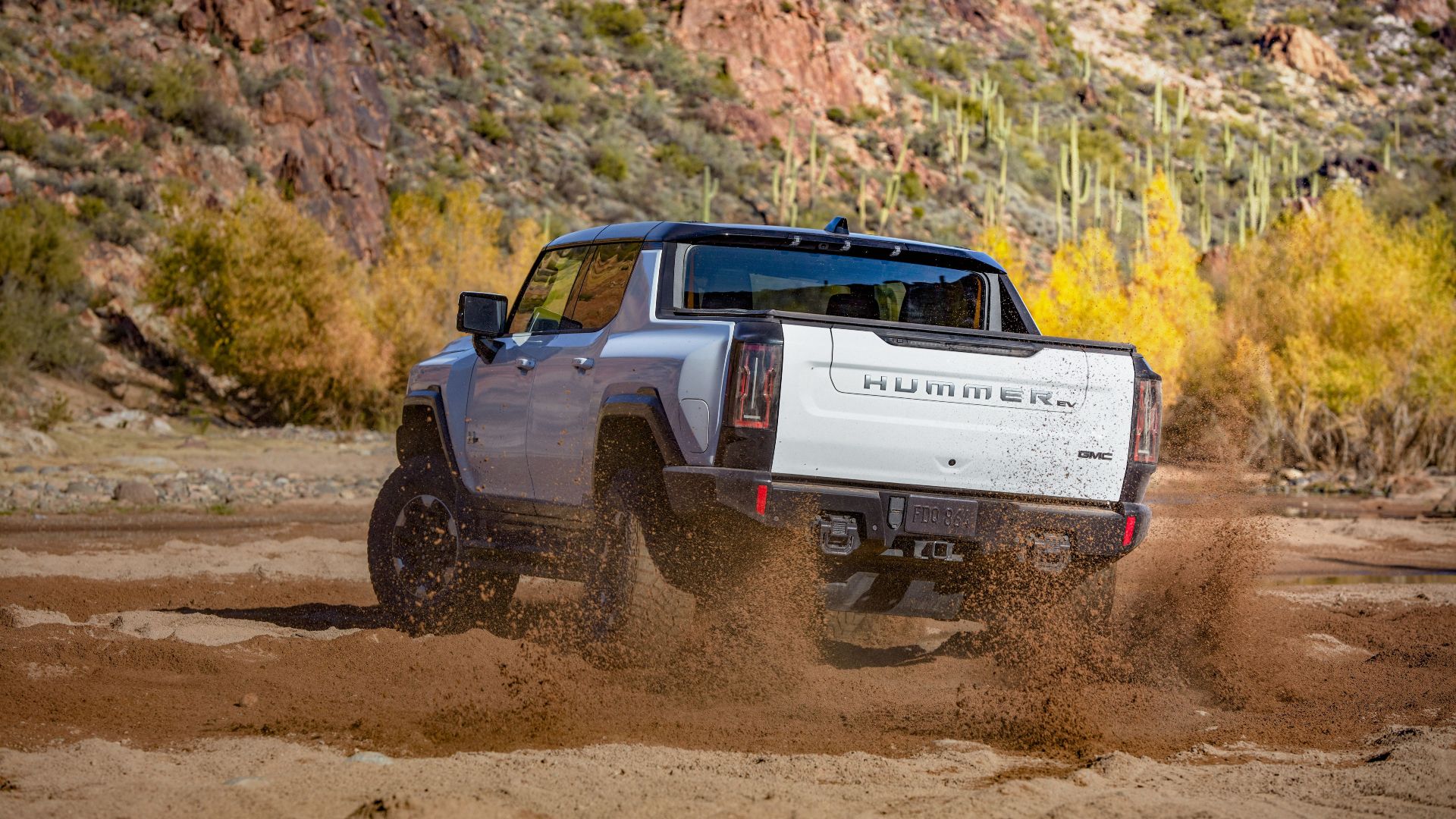 A rear side shot of a Hummer EV off-roading