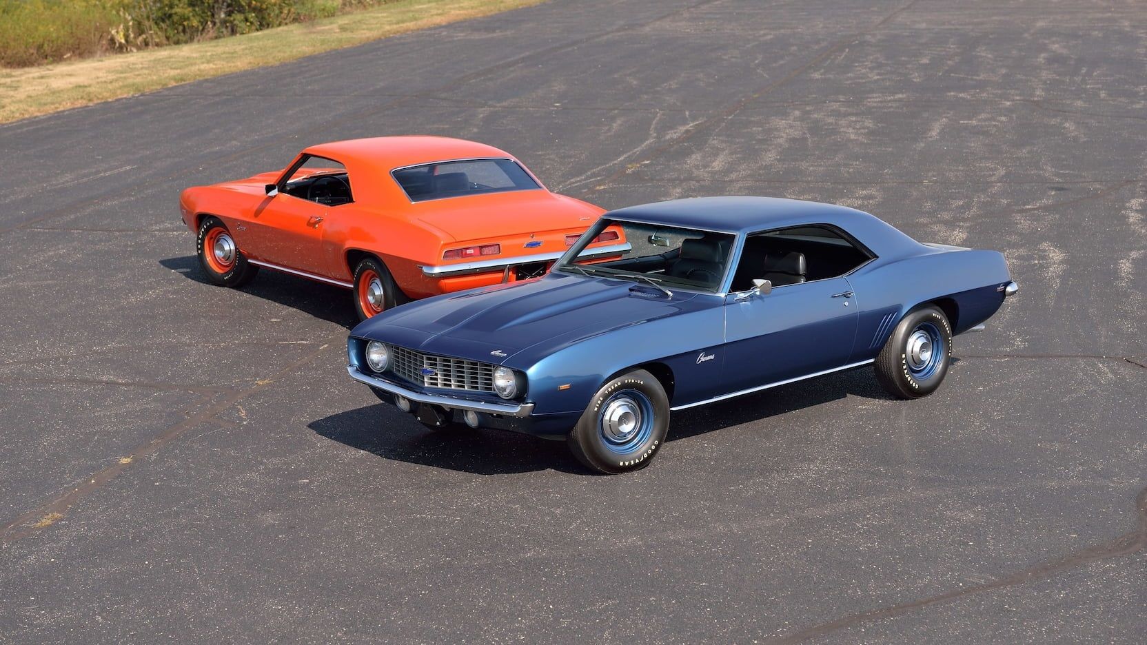 Um Chevrolet Camaro COPO 9560 ZL1 Dusk Blue e Hugger Orange 1969 estão lado a lado.
