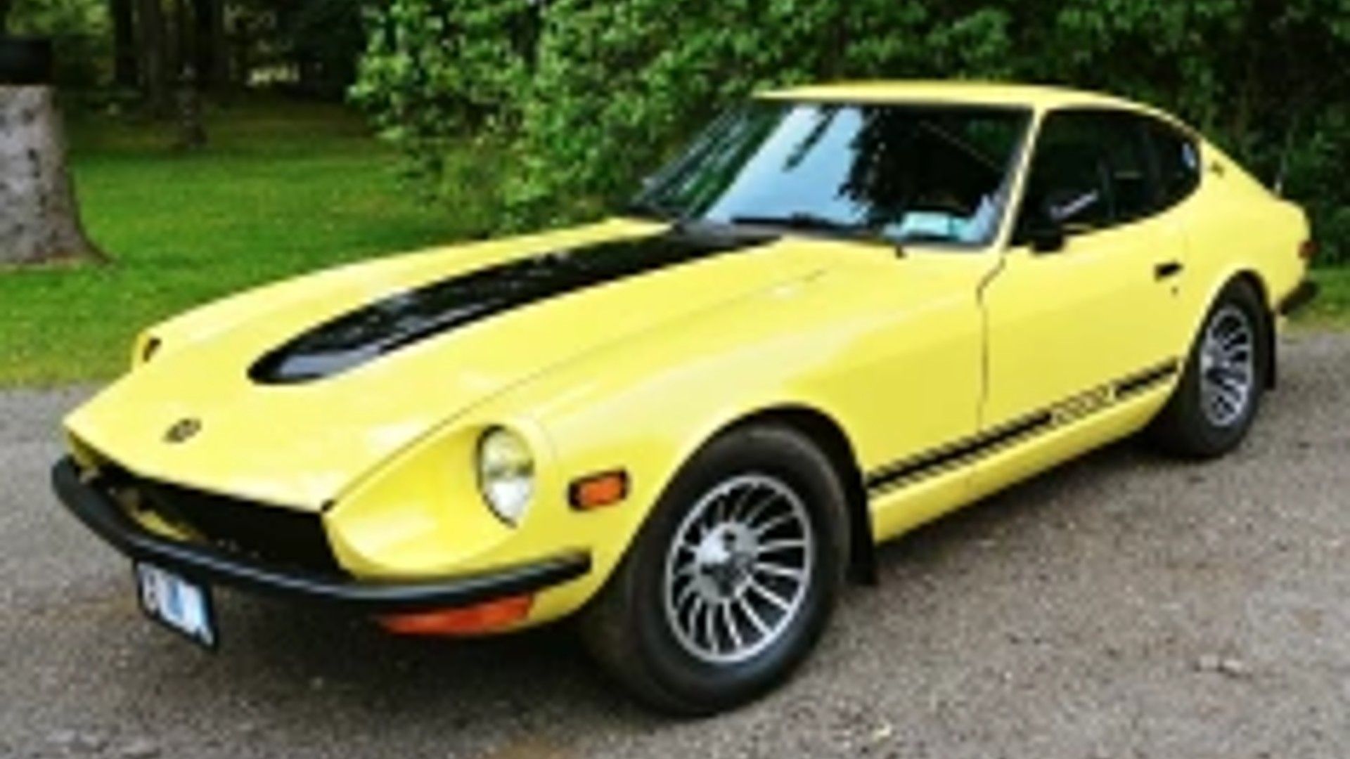 Shot of a yellow 1970 Nissan Fairlady Z with a black racing stripes. 