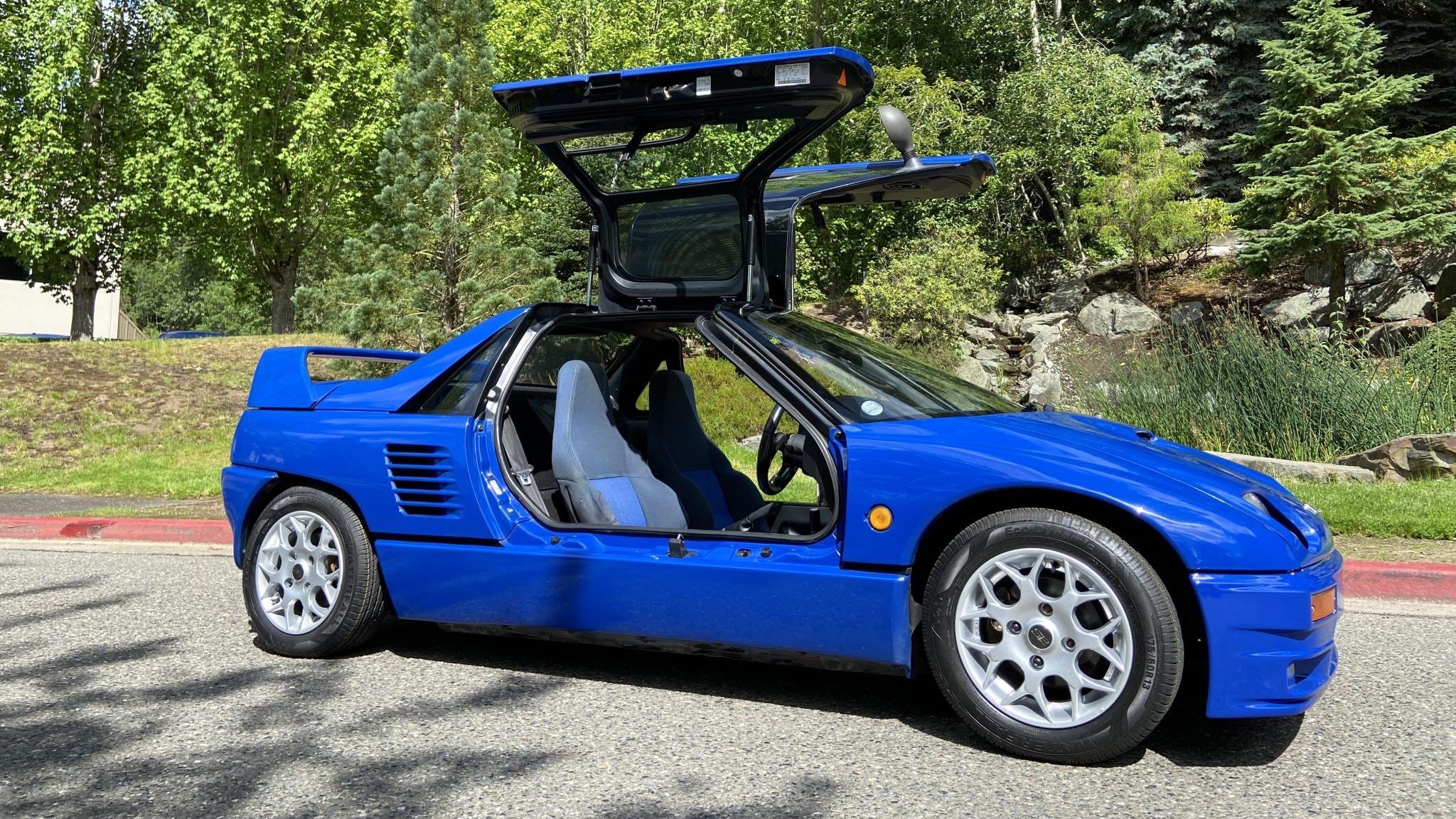 A blue 1993 Autozam AZ-1 with doors open.