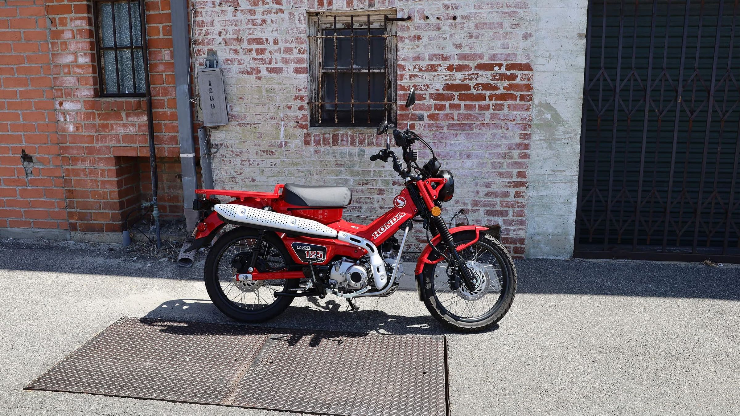 A side right shot of a red 2022 Honda Trail 125