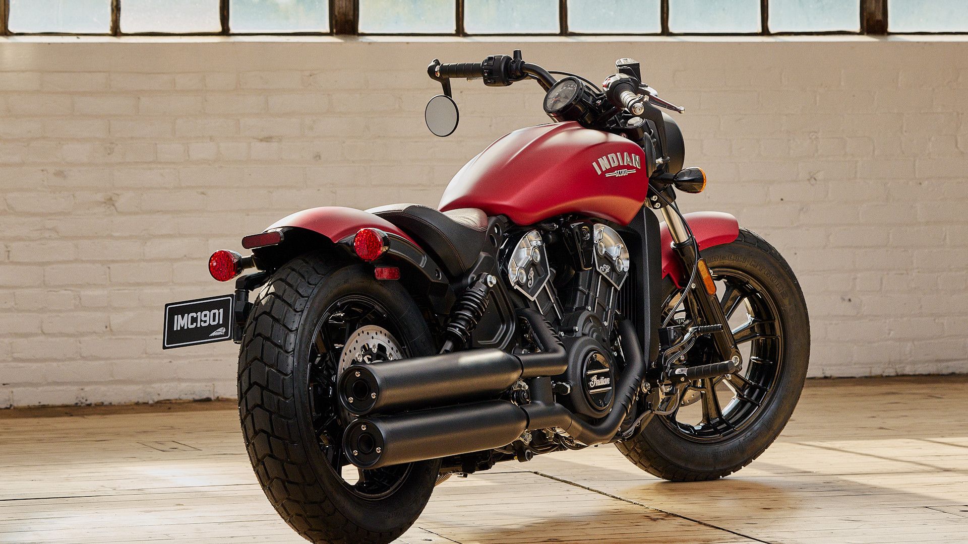 Red 2023 Indian Scout Bobber parked in a warehouse