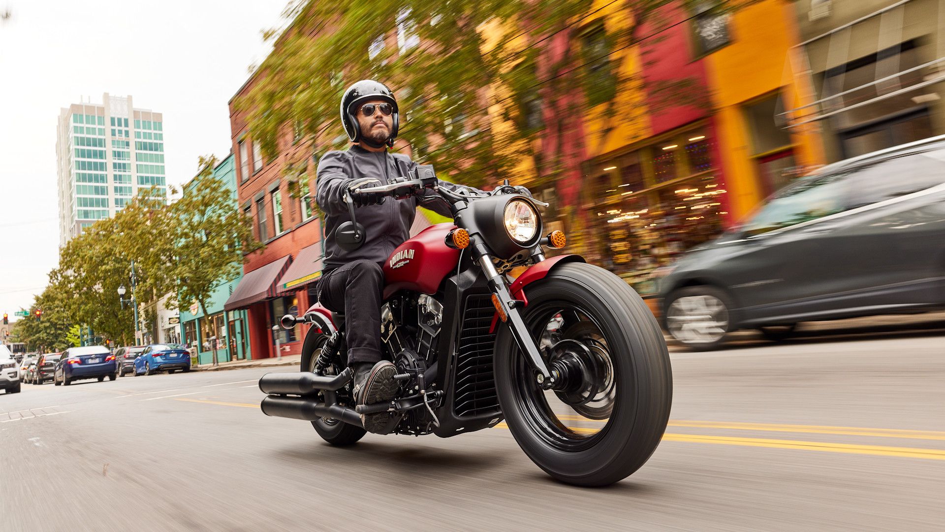 Red 2023 Indian Scout Bobber cruising through town