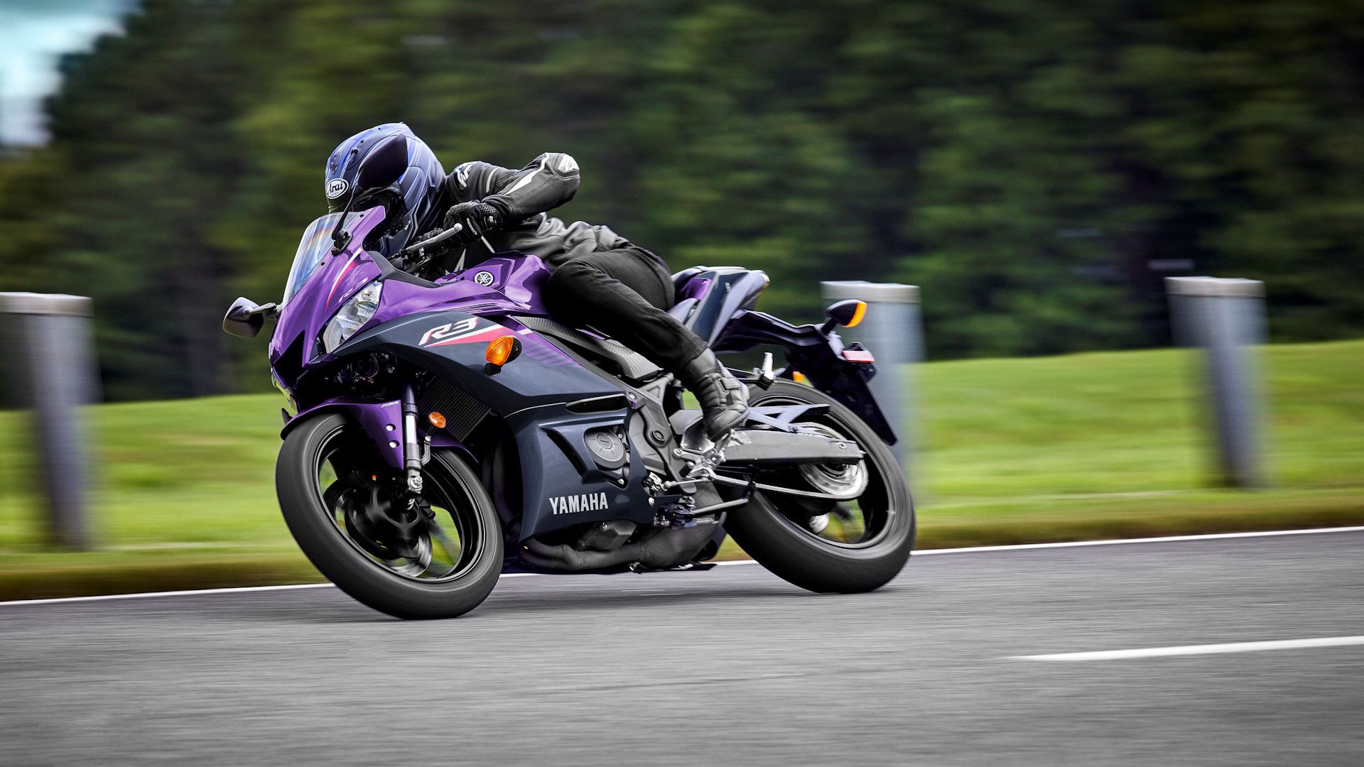 Purple 2023 Yamaha YZF-R3 leaning into a bend