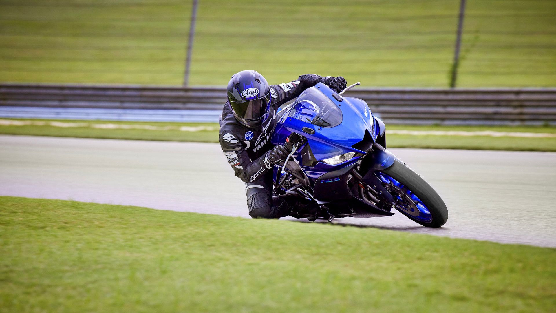 Blue 2023 Yamaha YZF-R3 leaning into a curve