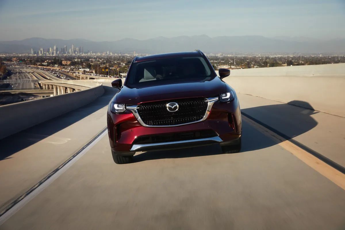 Burgundy Mazda CX-90 front shot driving