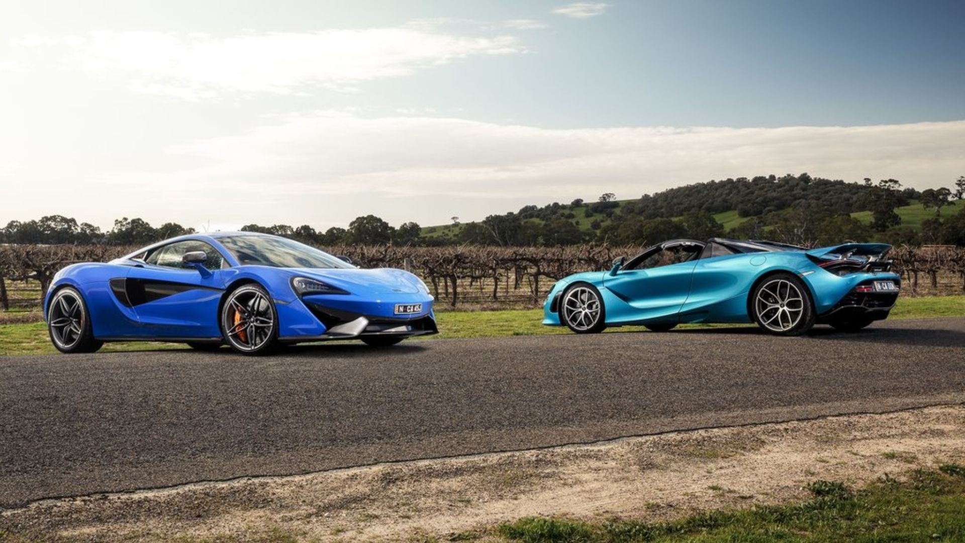 Perfil lateral de dois McLaren 720S estacionados na estrada