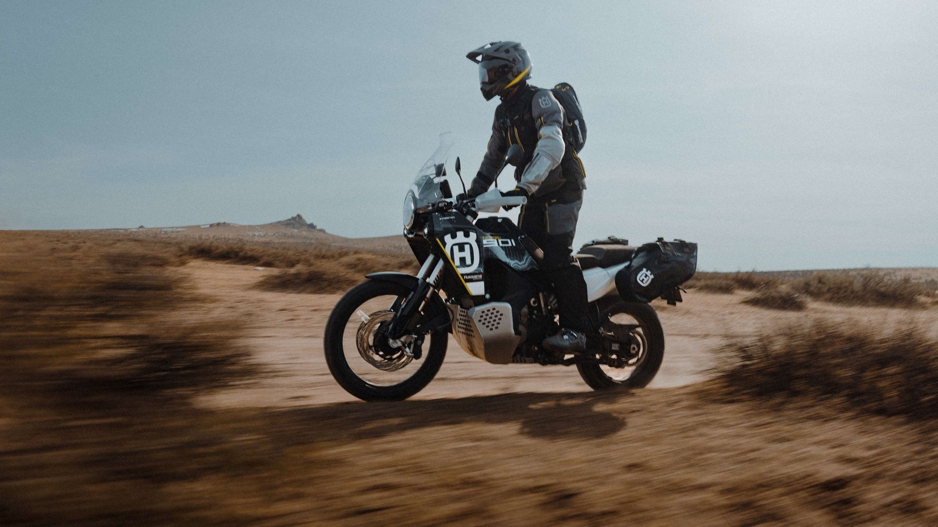 An action side left shot of a 2023 Husqvarna Norden 901 Expedition riding off-road