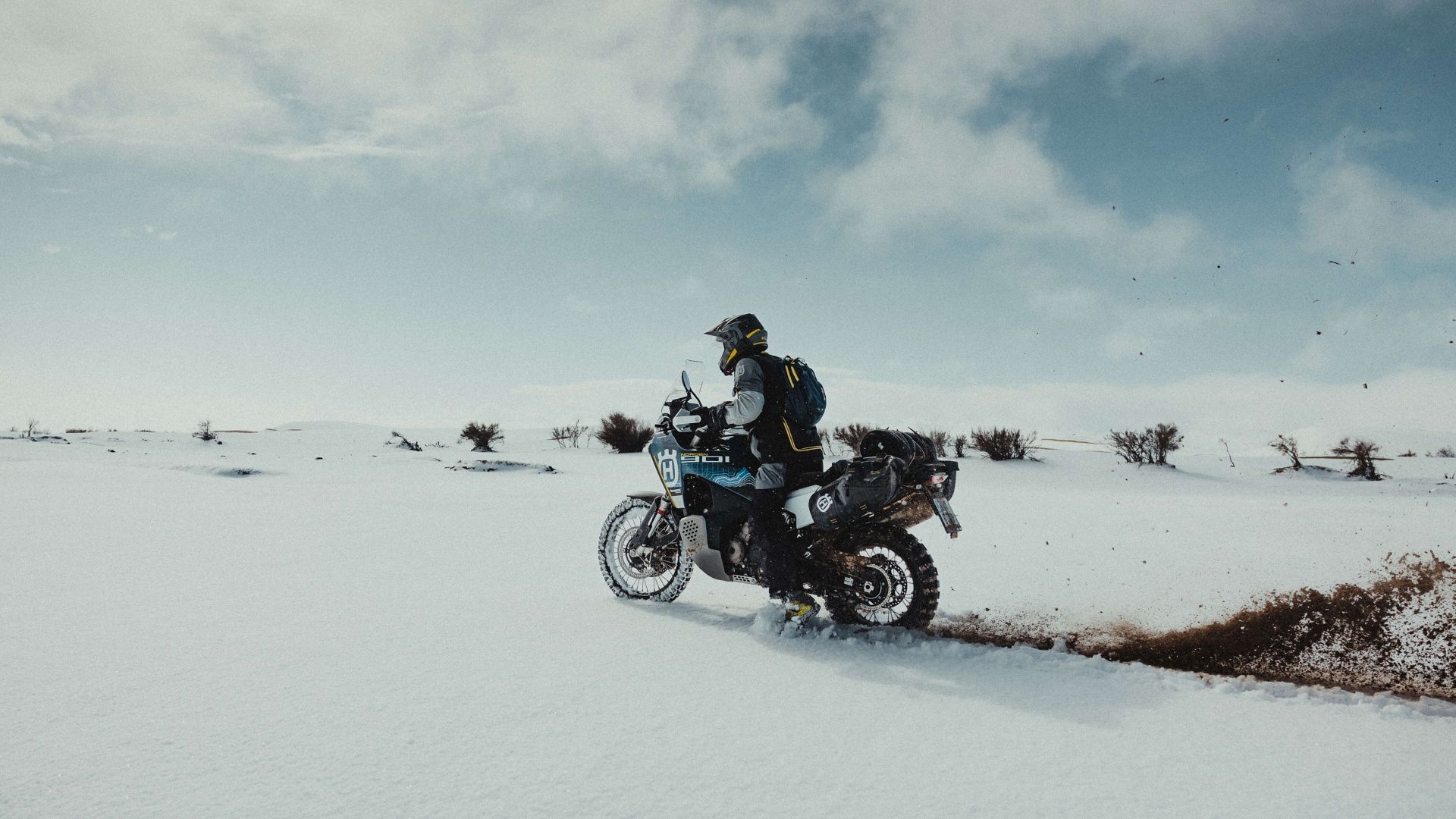 An action shot of a 2023 Husqvarna Norden 901 Expedition on the snow