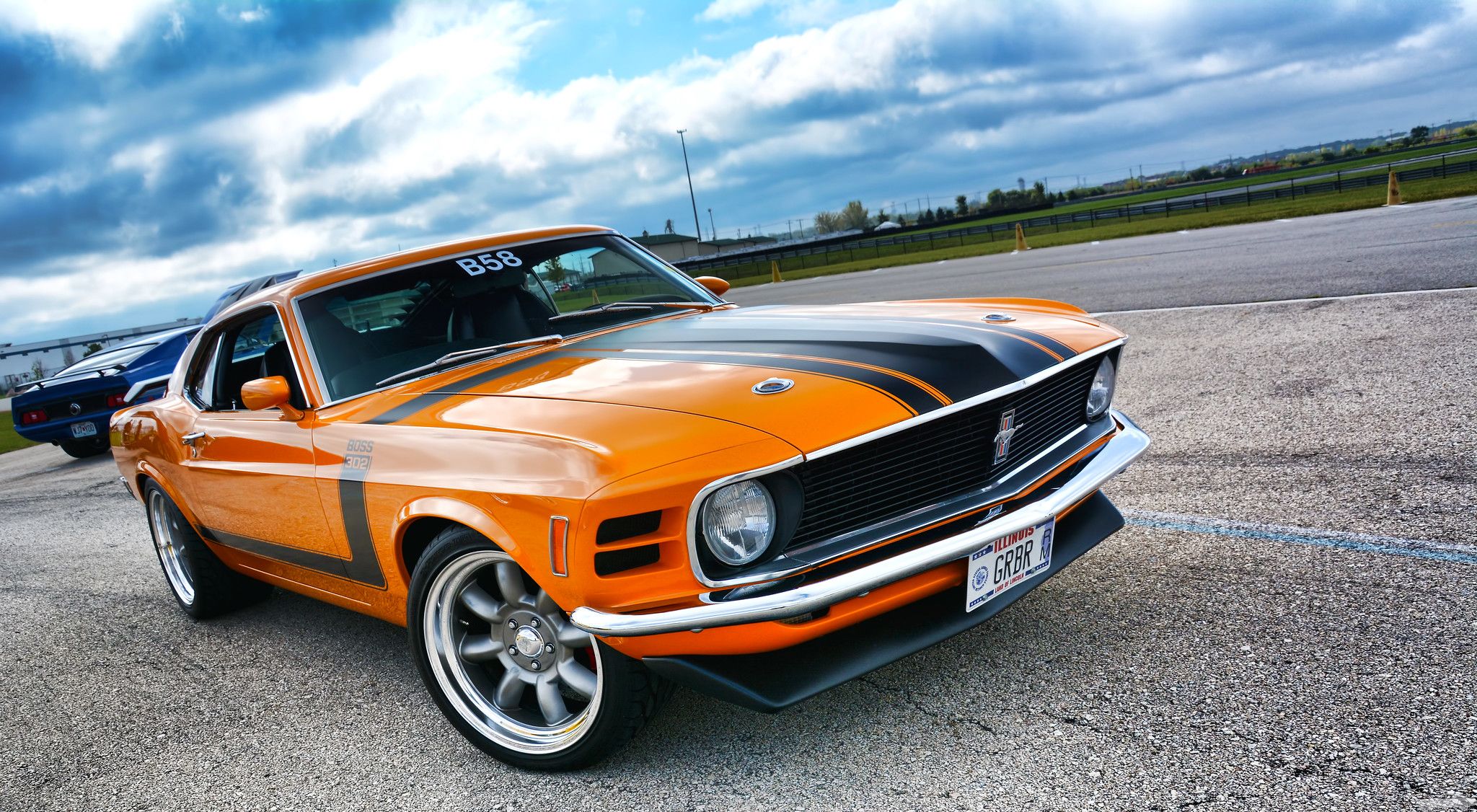Um Mustang Boss 302 laranja 1970 com listras pretas de corrida