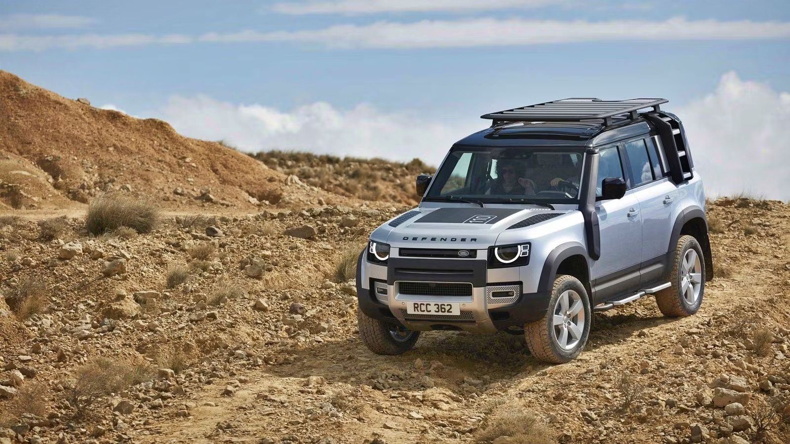 Silver Land Rover Defender On A Dirt Trail