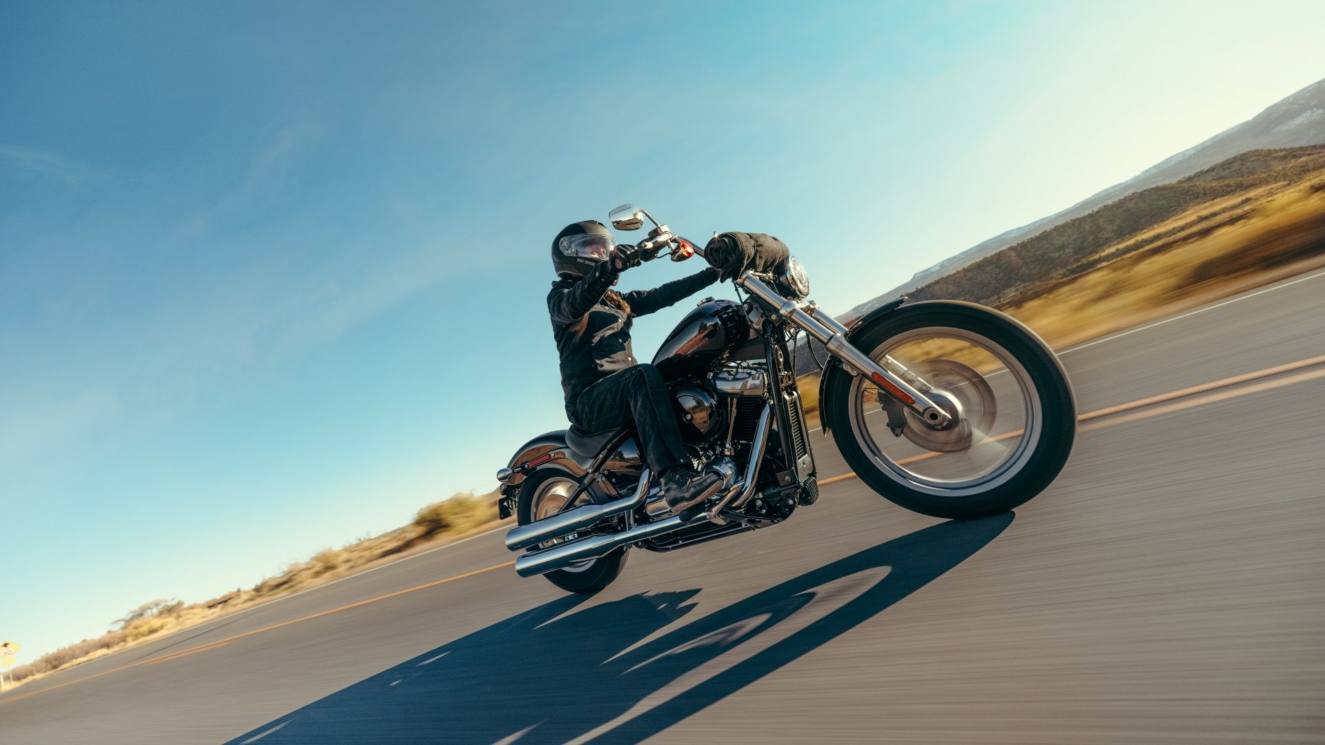 Bidikan aksi dari Harley-Davidson Softail Standard 2023 yang sedang berkendara di jalan