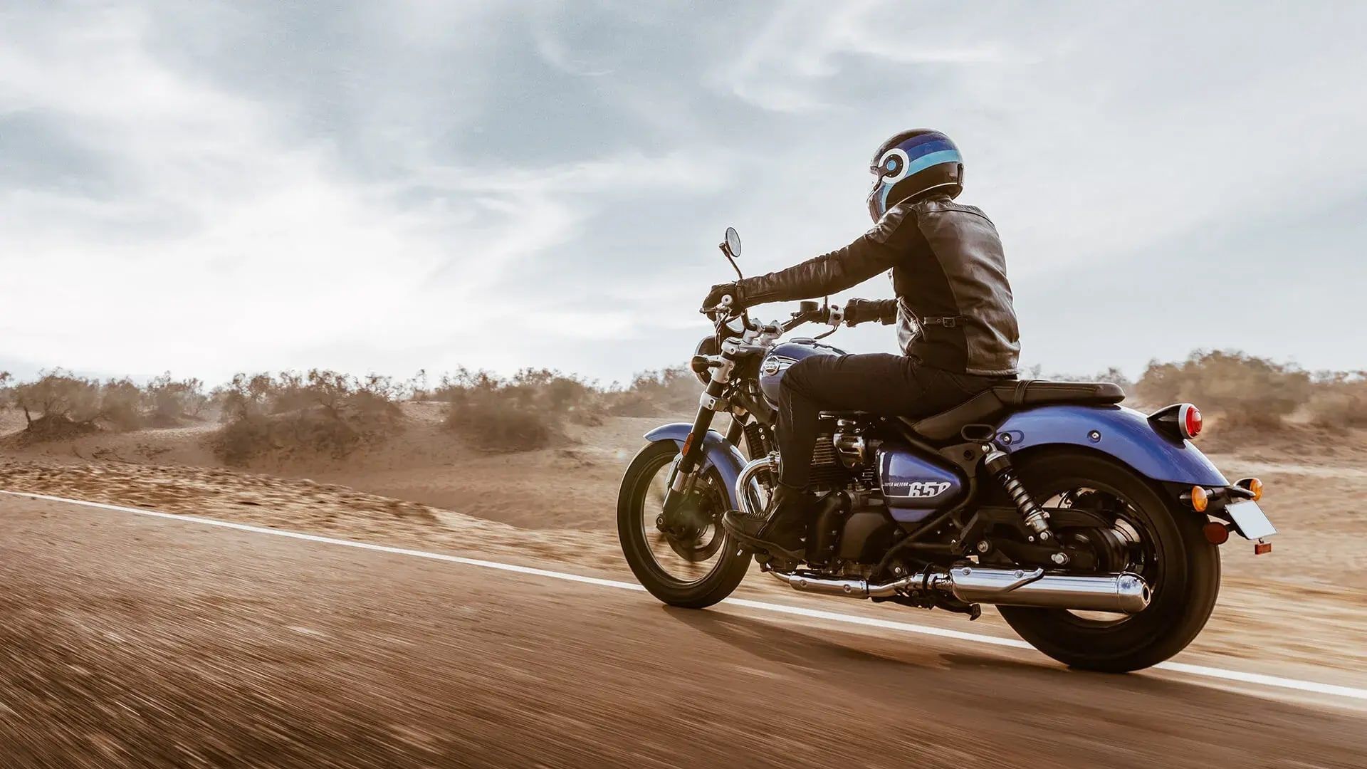 Blue 2023 Royal Enfield Super Meteor 650 cruising up the road