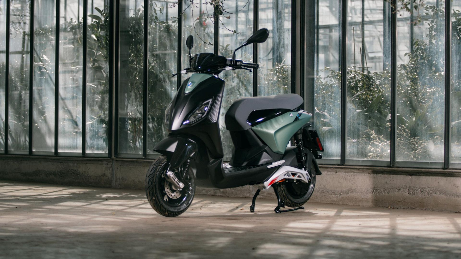 Green 2023 Piaggio 1 parked in a showroom