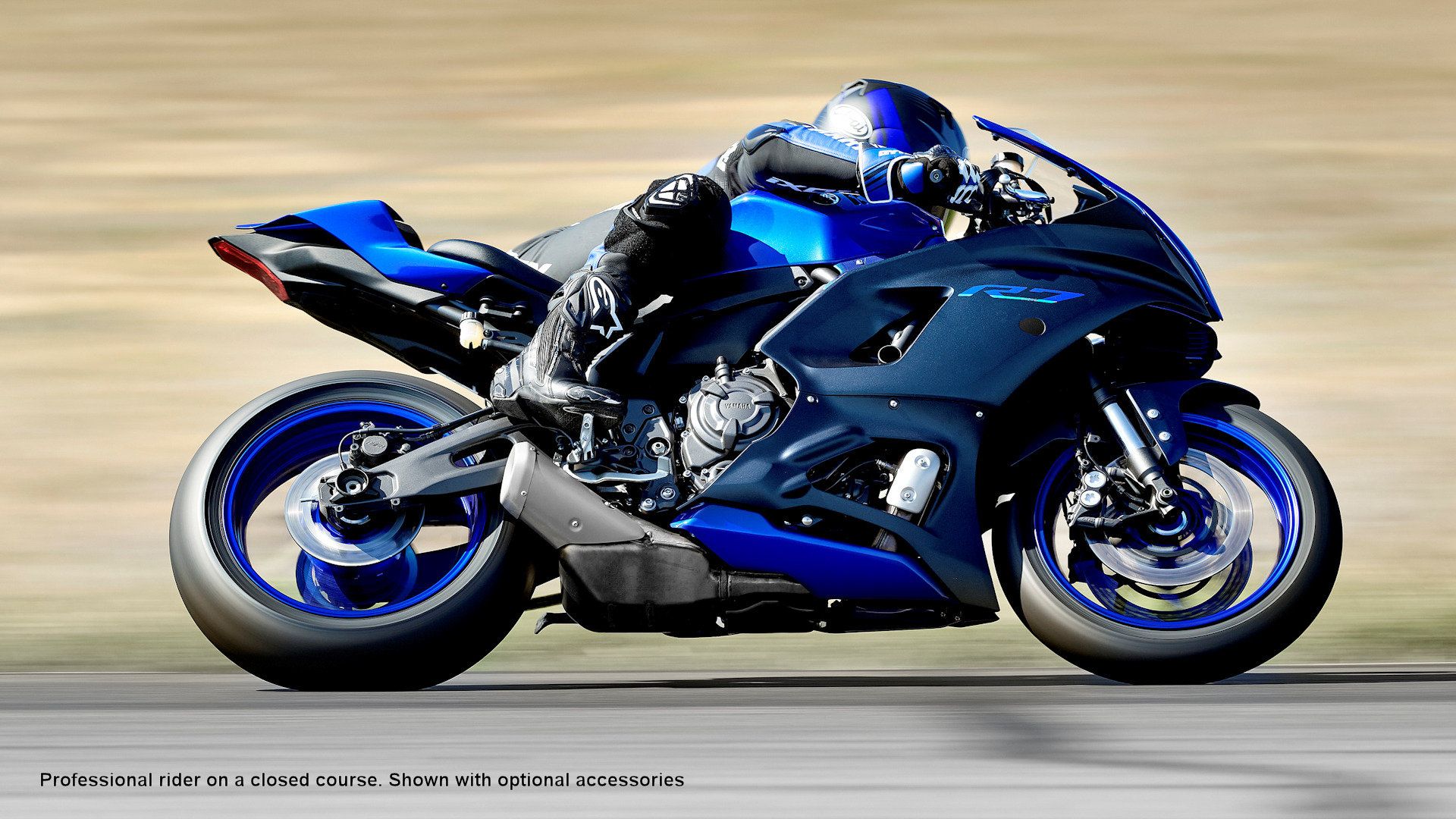 Blue 2023 Yamaha YZF-R7 on the track leaning into a curve