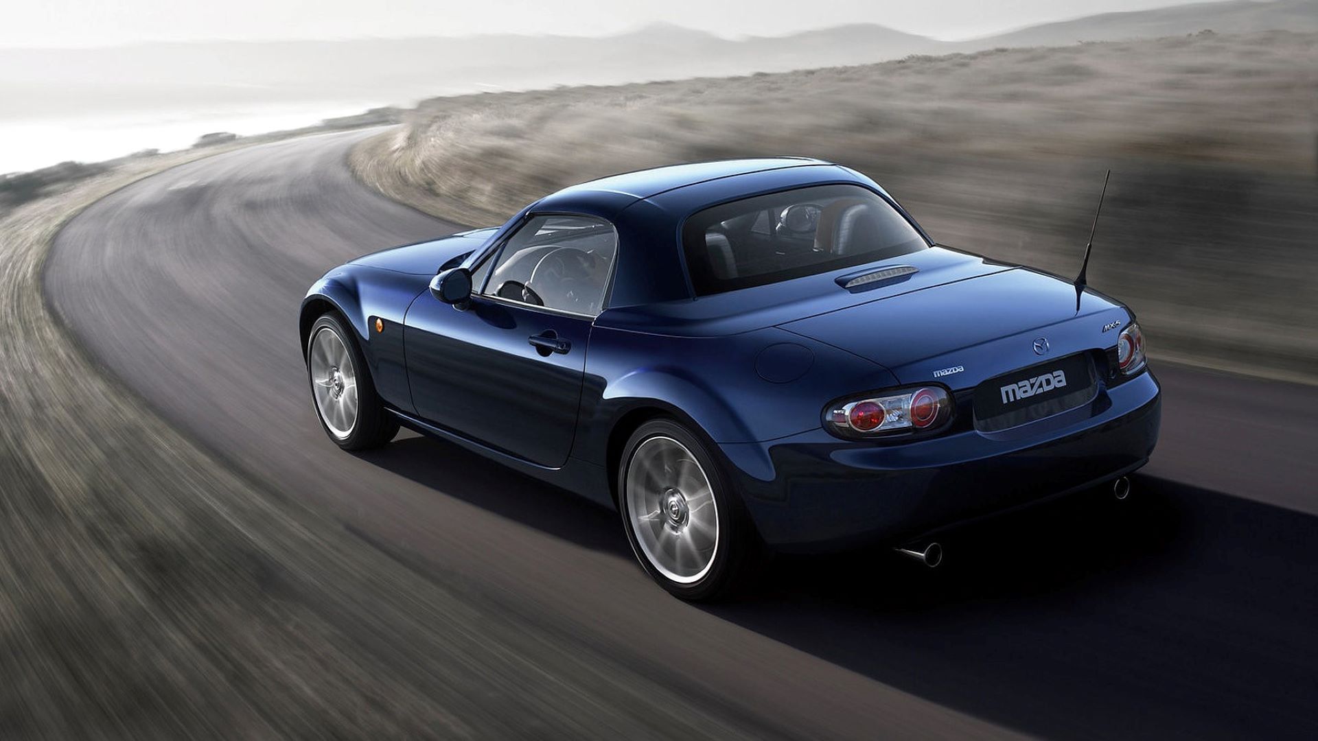 Πίσω λήψη δράσης ενός Mazda MX-5 Miata Roadster Coupe του 2006