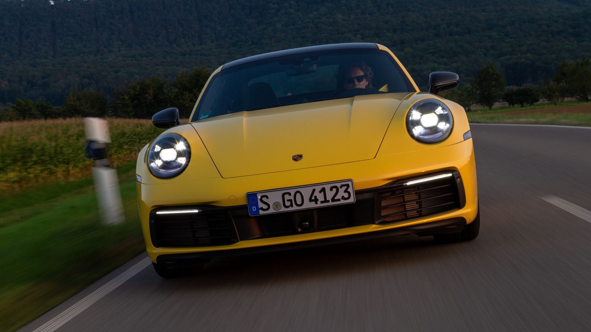 Front shot of a 2023 Porshce 911 speeding down a road
