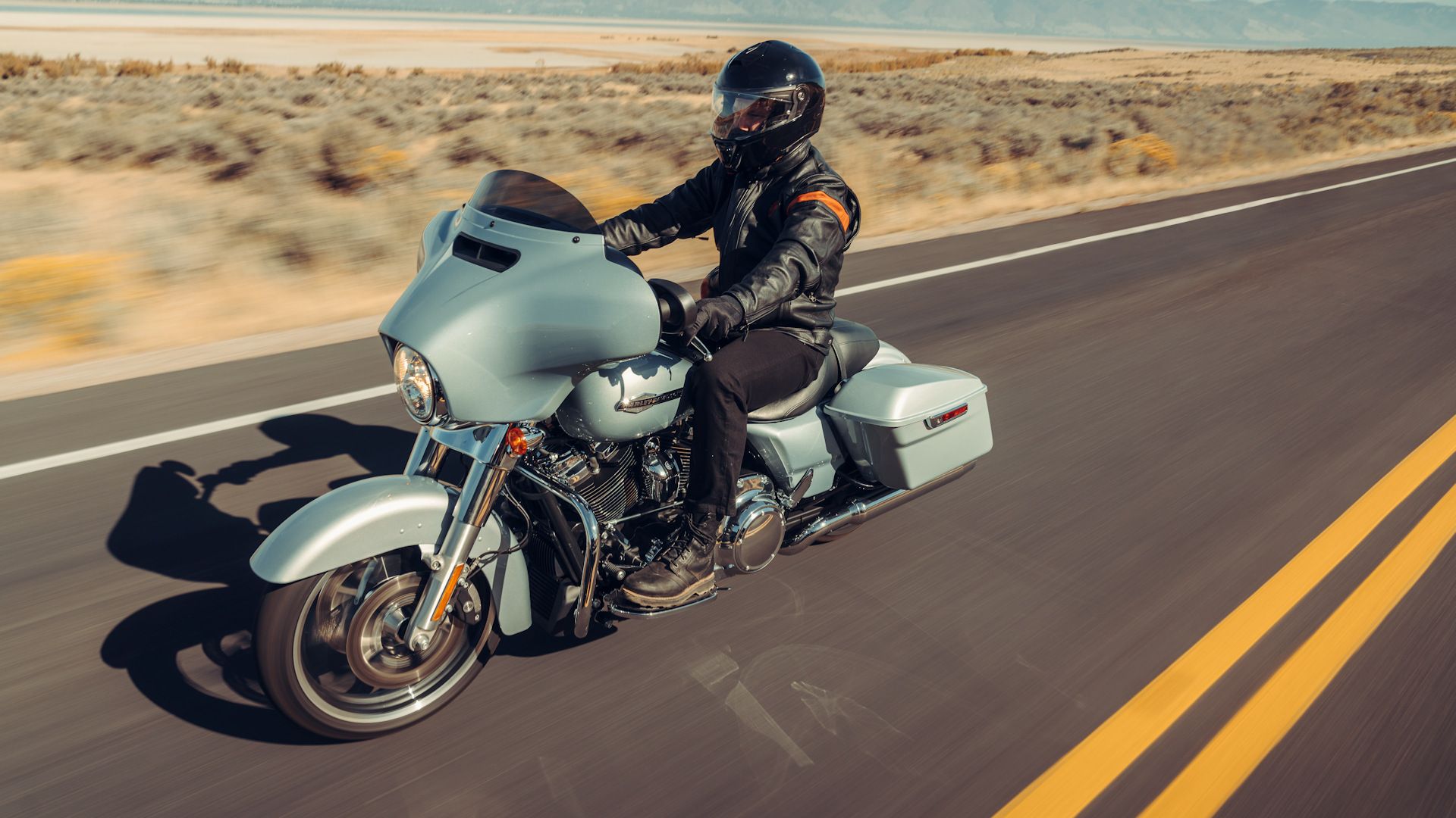 Silver 2023 Harley-Davidson Street Glide cruising up the road