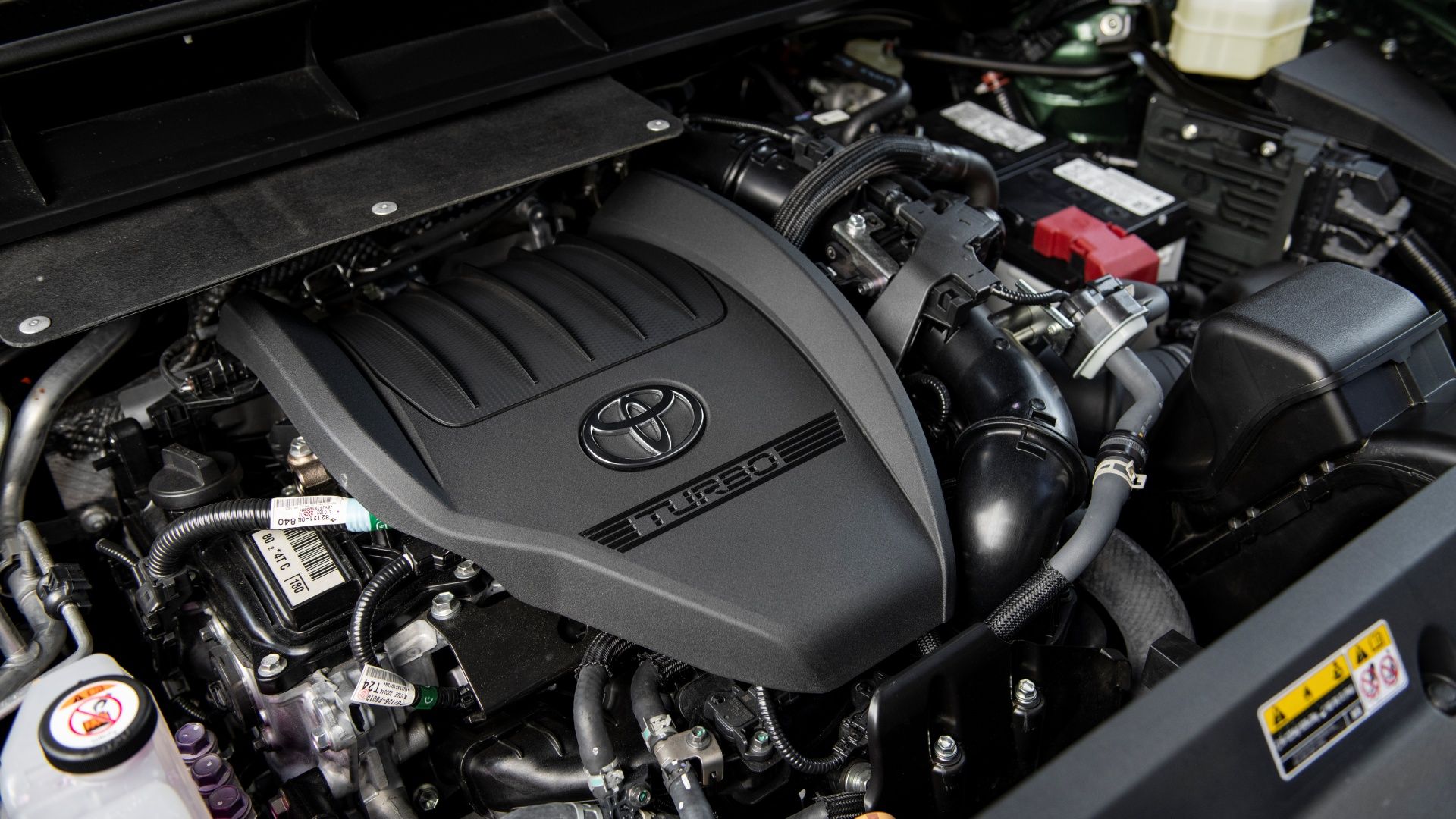 A studio shot of the turbocharged engine of a 2023 Highlander Turbo Limited Cypress Green
