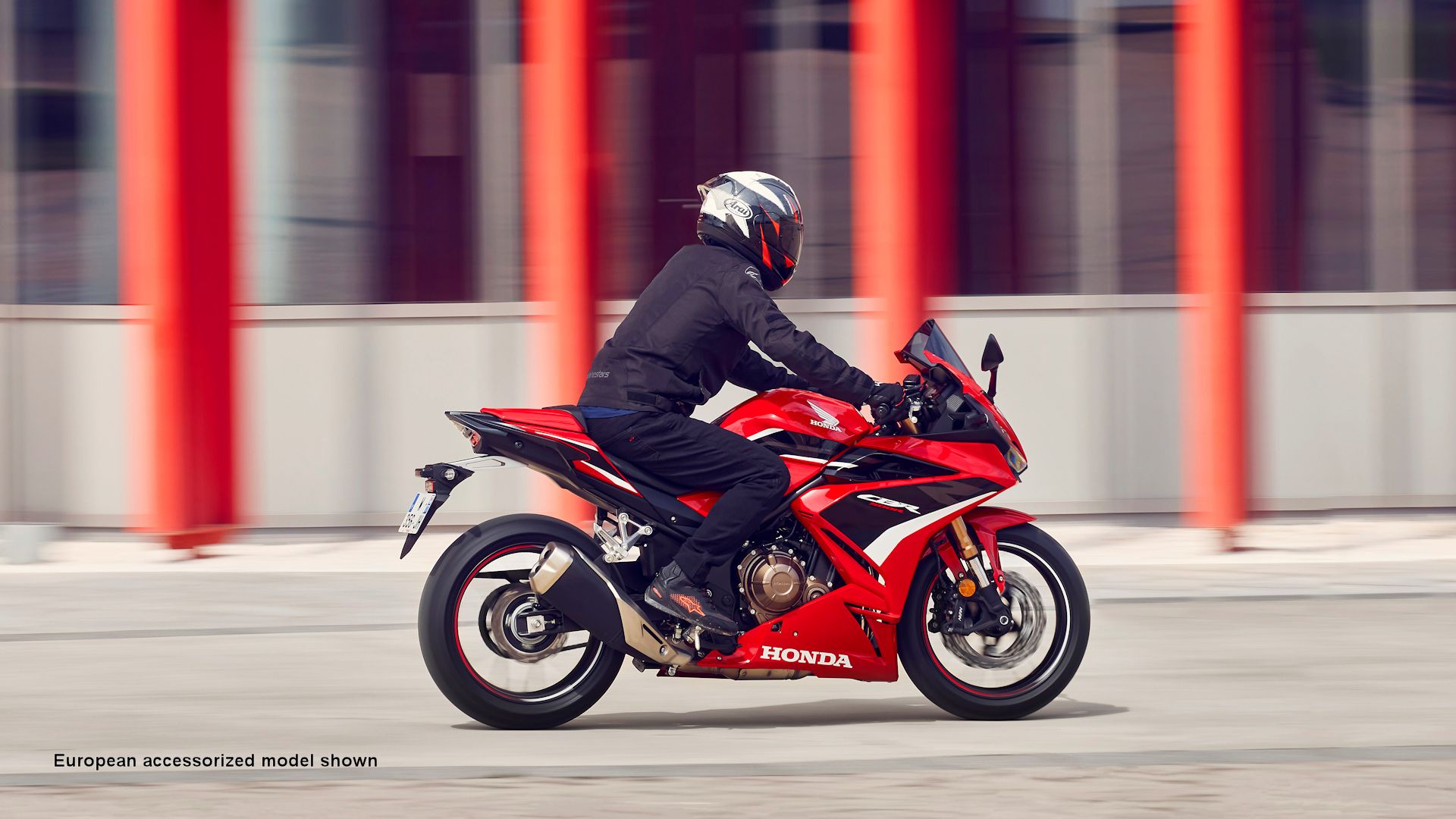 Red 2022 Honda CBR500R cruising through town