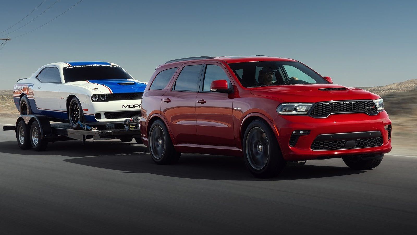 Red Dodge Durango towing a Challenger