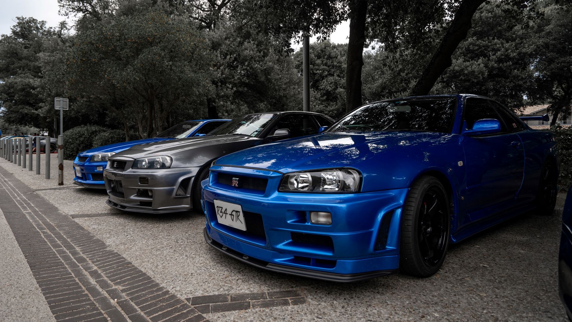 Front 3/4 shot of three Nissan Skyline GT-R R34s parked