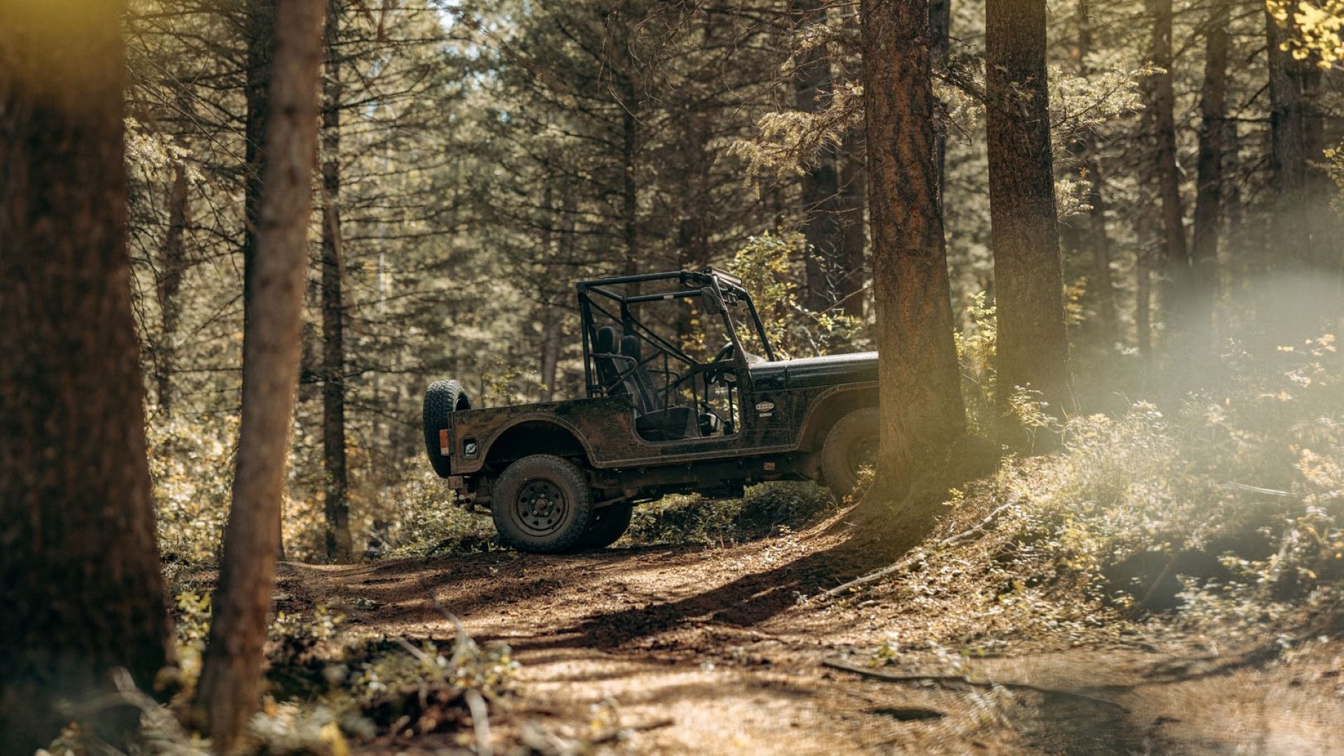 The 2023 Mahindra Roxor off-roading in a forest