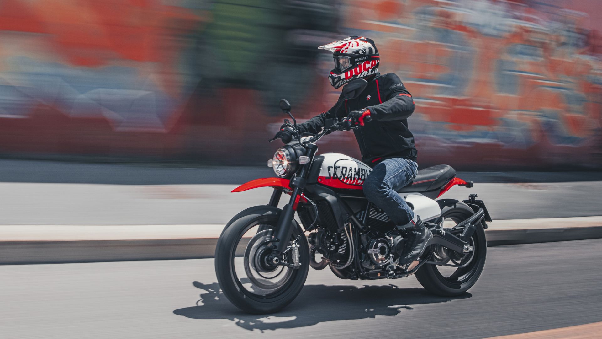 White 2022 Ducati Scrambler Urban Motard cruising along the road