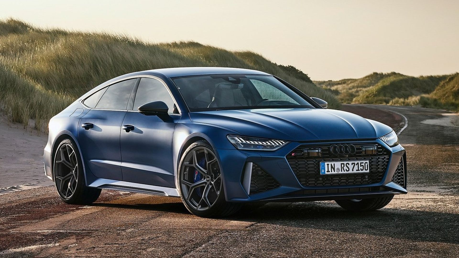 Three-quarter view of the 2023 Audi RS7 Sportback Performance parked in front of sand dunes