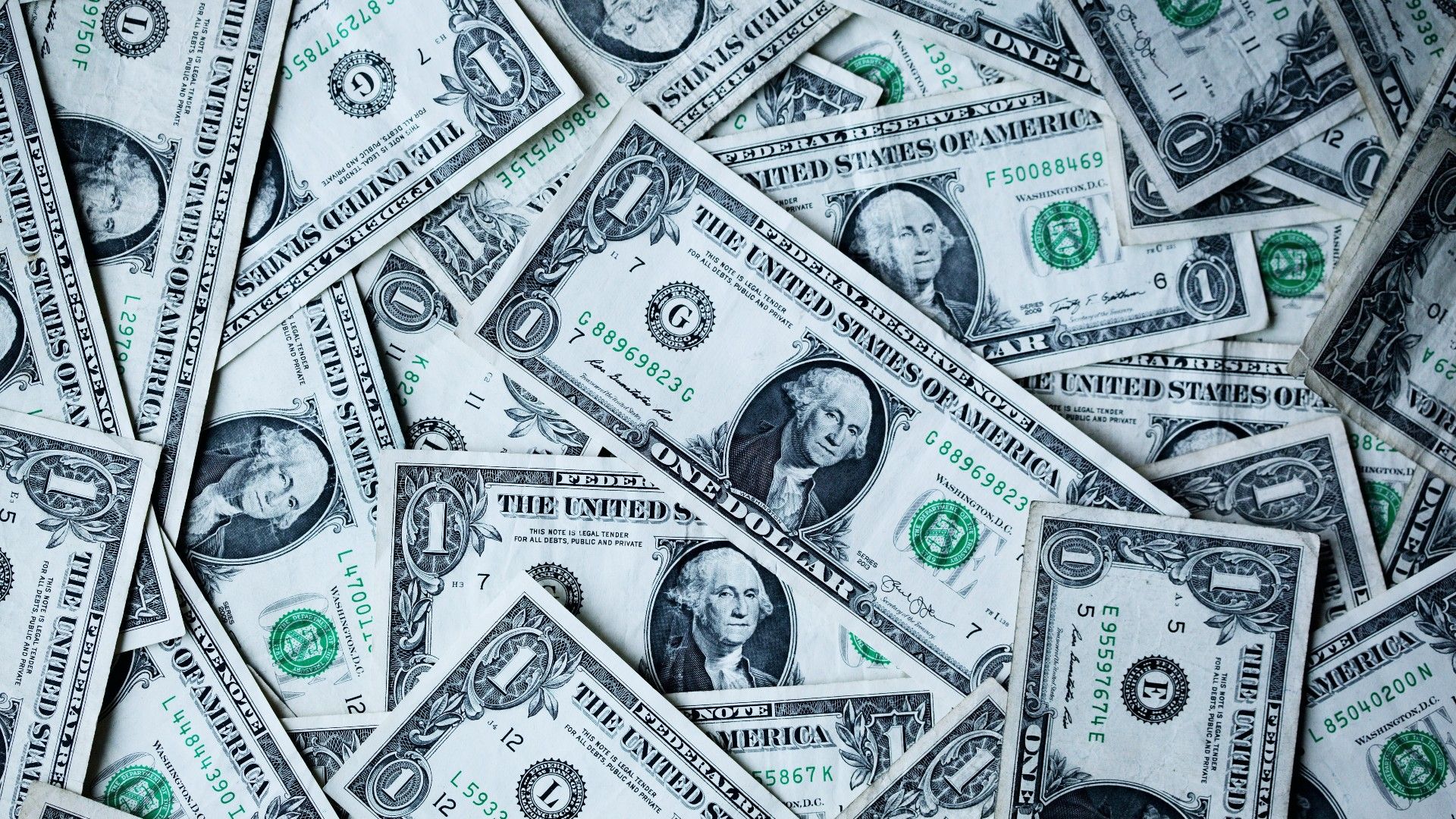 A pile of single dollar bills representing a fee, taxation or other monetary cost.