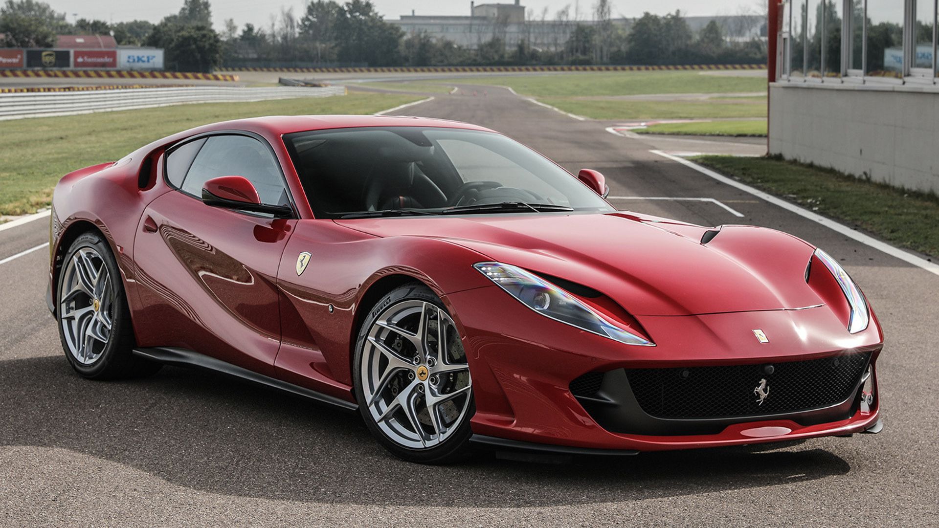 Three-quarter view of red Ferrari 812 Superfast parked on a race track