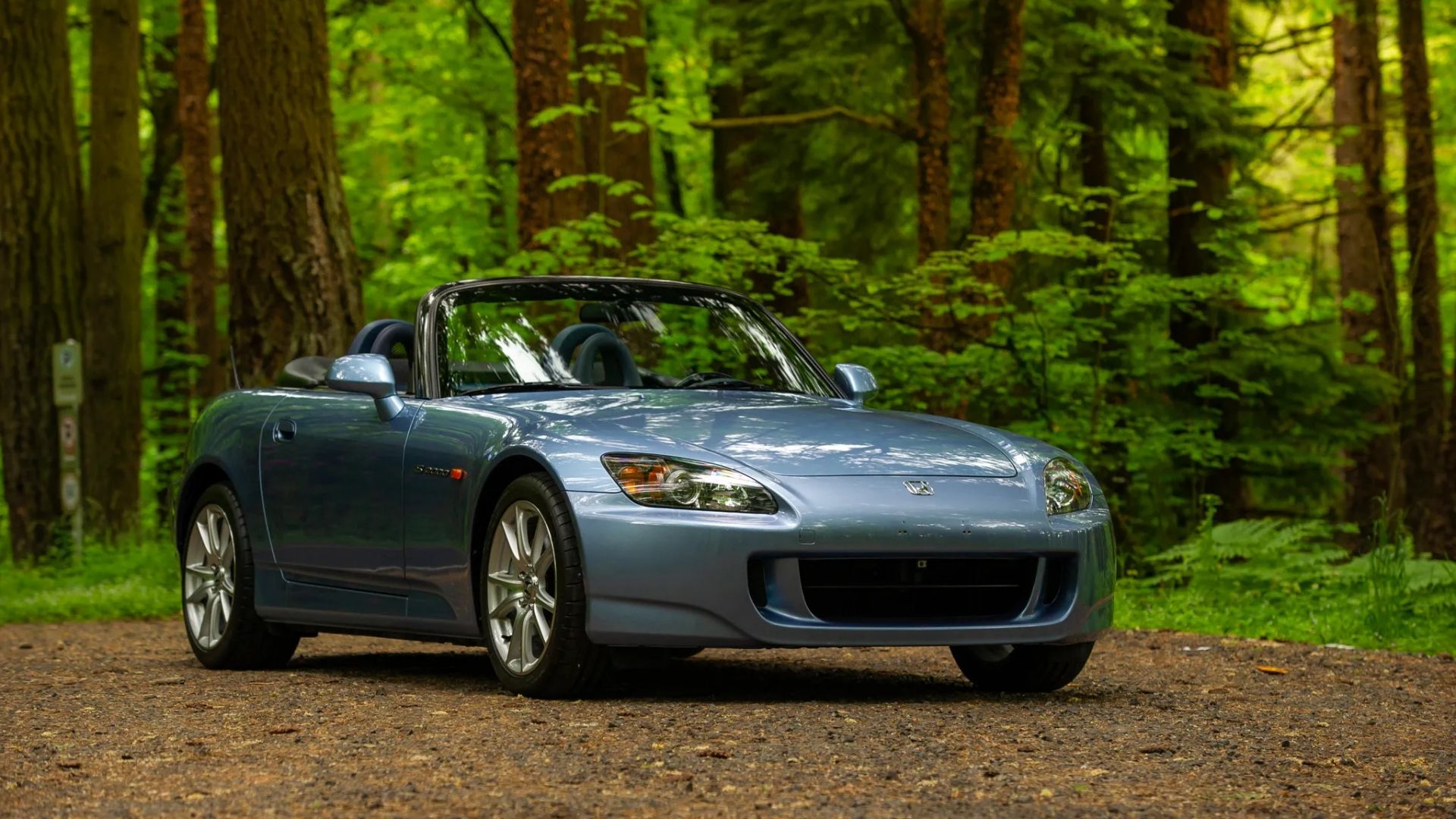 Honda S2000 in light blue parked in forest