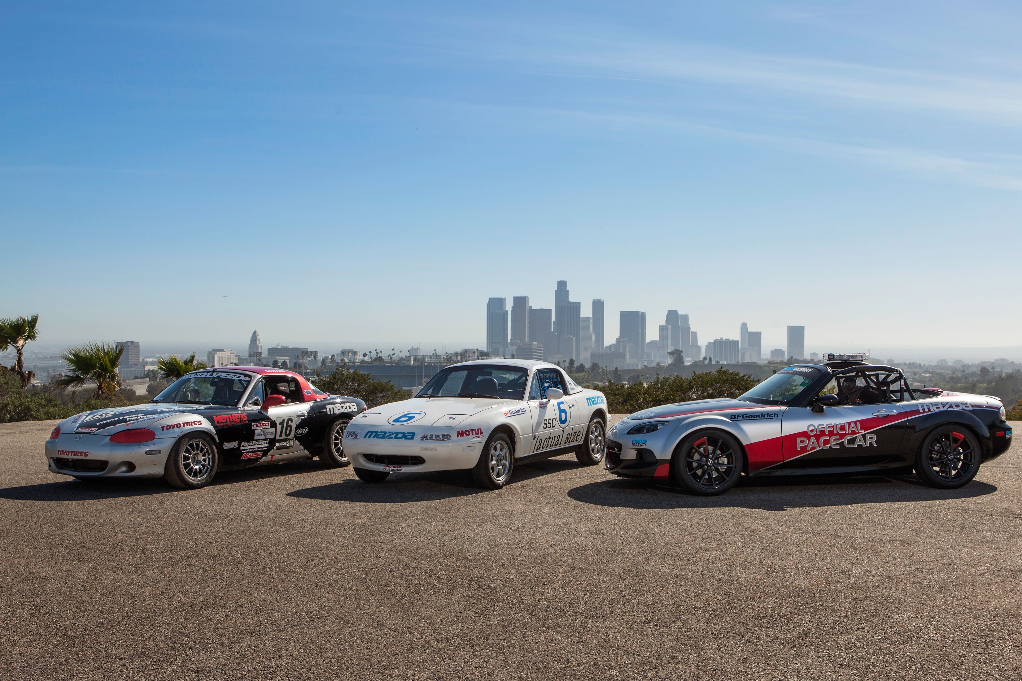 Imagem capturando carros esportivos Mazda MX-5 em um cenário de automobilismo, enfatizando o desempenho do carro e a herança das corridas.