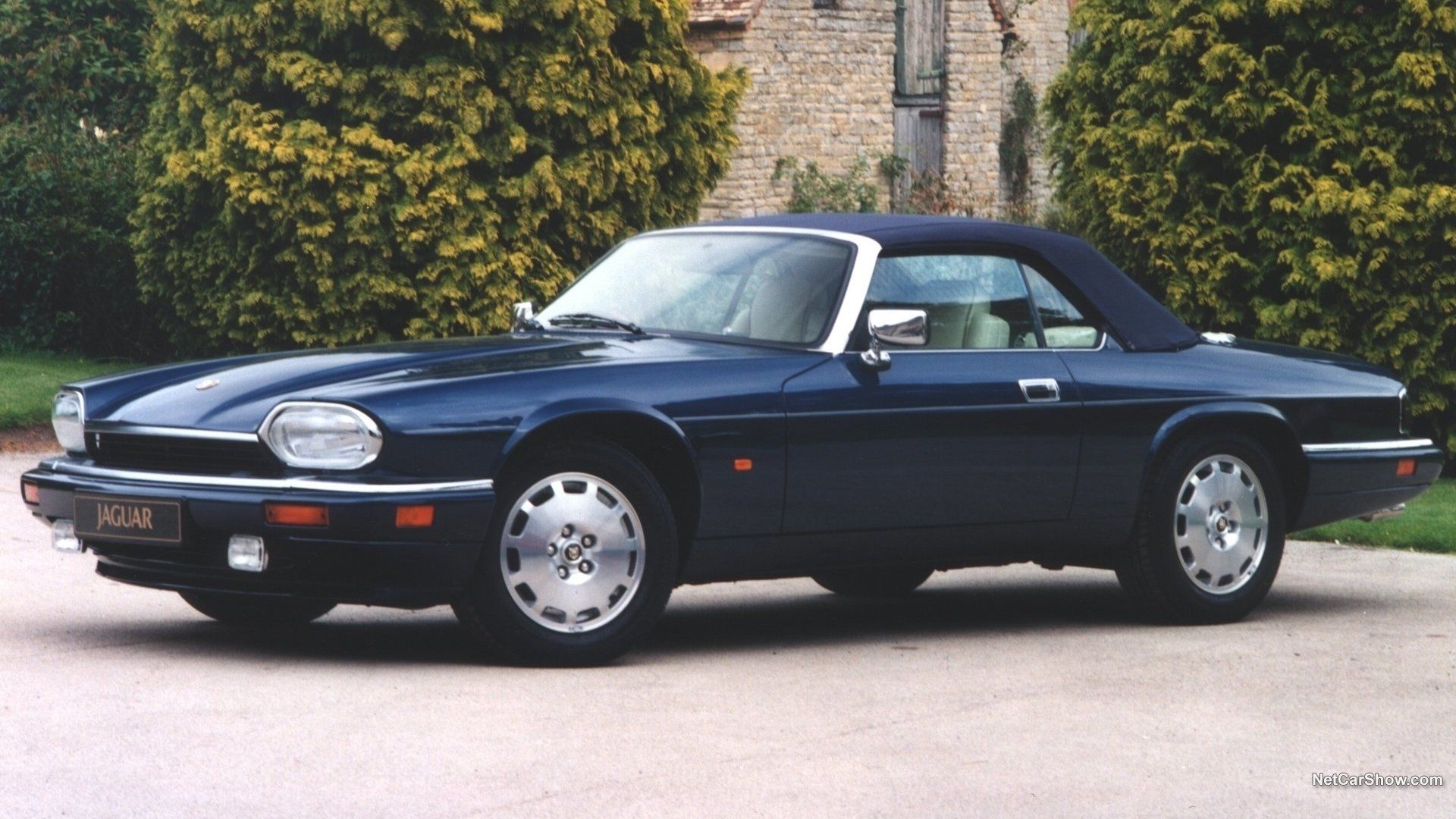 1996 Jaguar XJS V-12 in blue posing in front of a country home